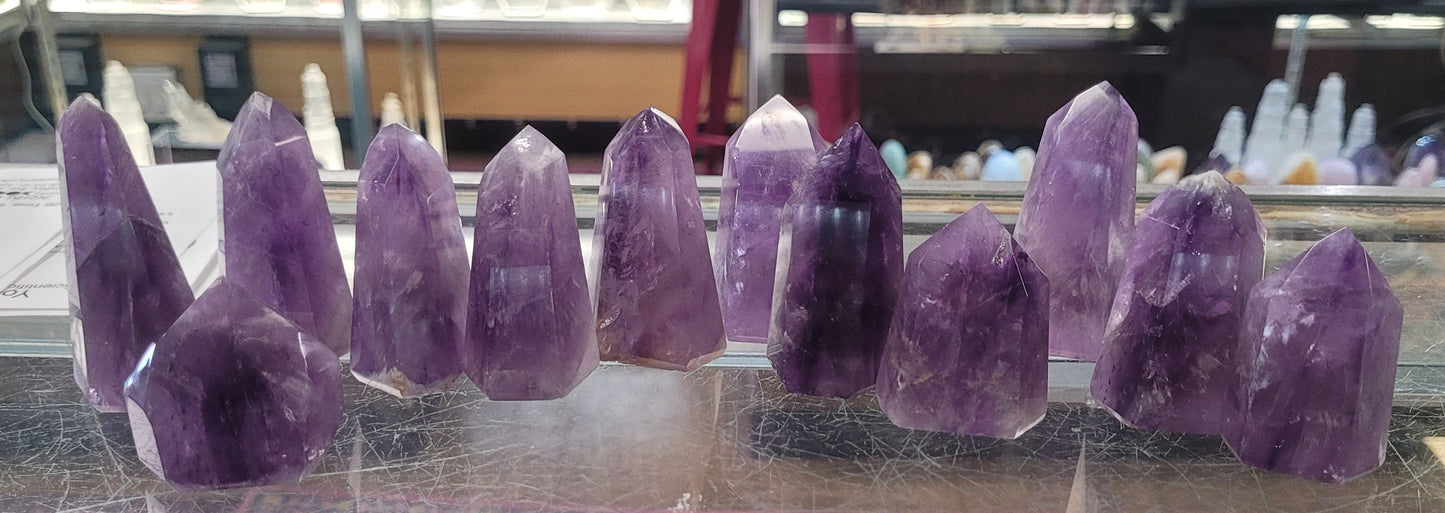 Purple crystal points hanging from a ceiling in a store setting