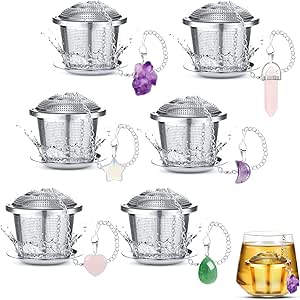 Set of metal tea infusers with decorative elements on a white background