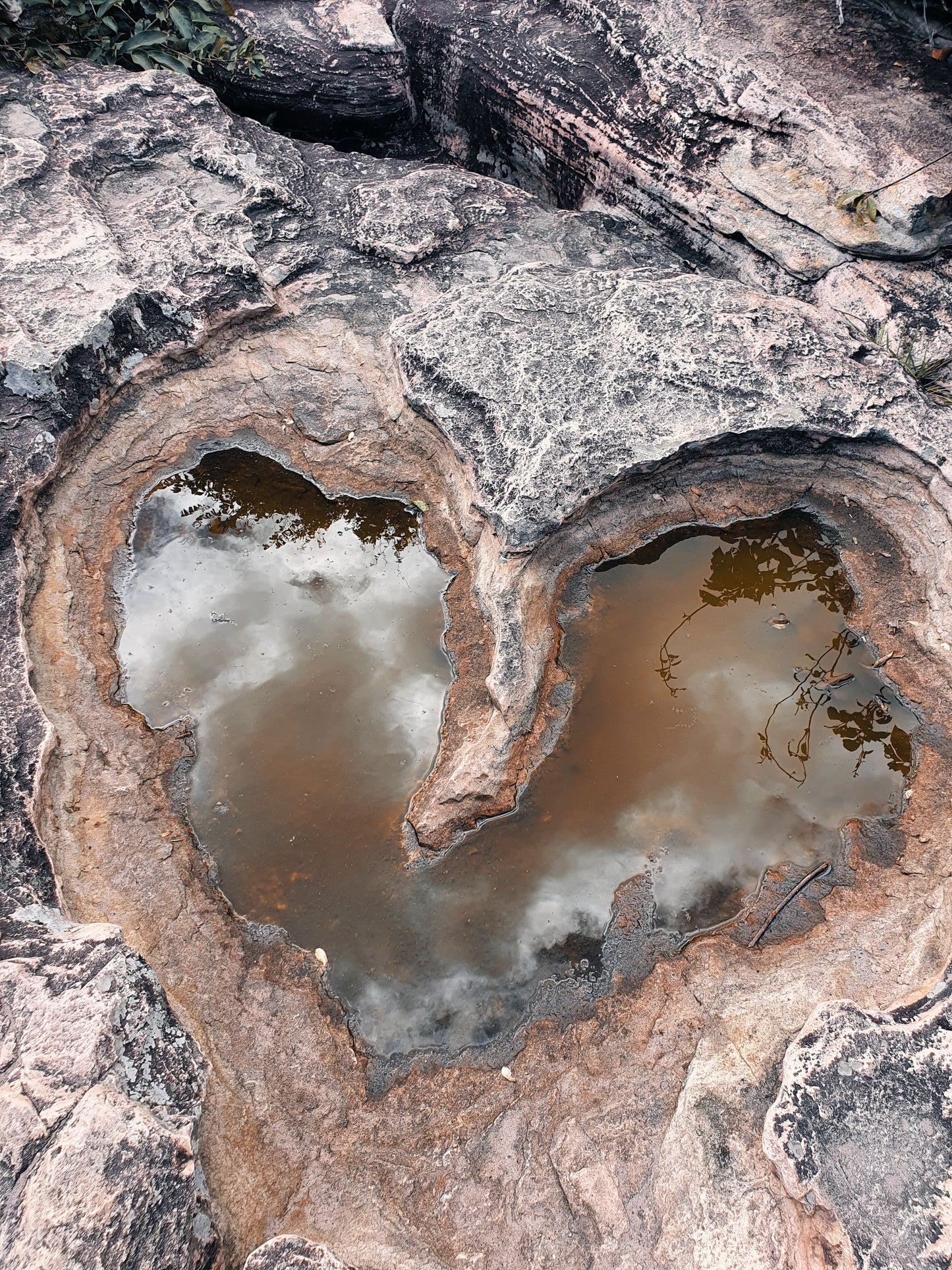 heart carved in stone with a pool of water reflecting in it.