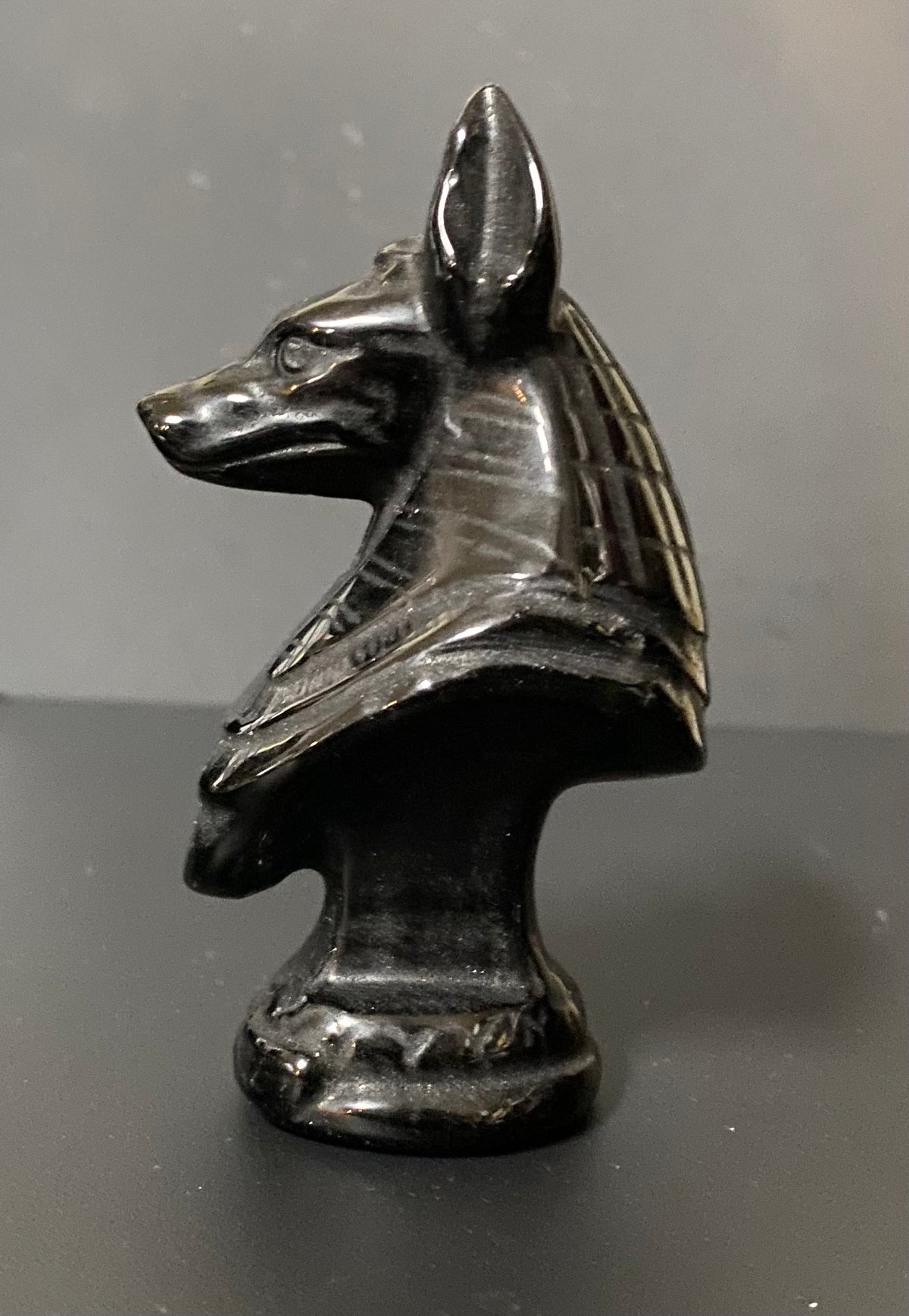 Obsidian Anubis Bust on a black background. side view