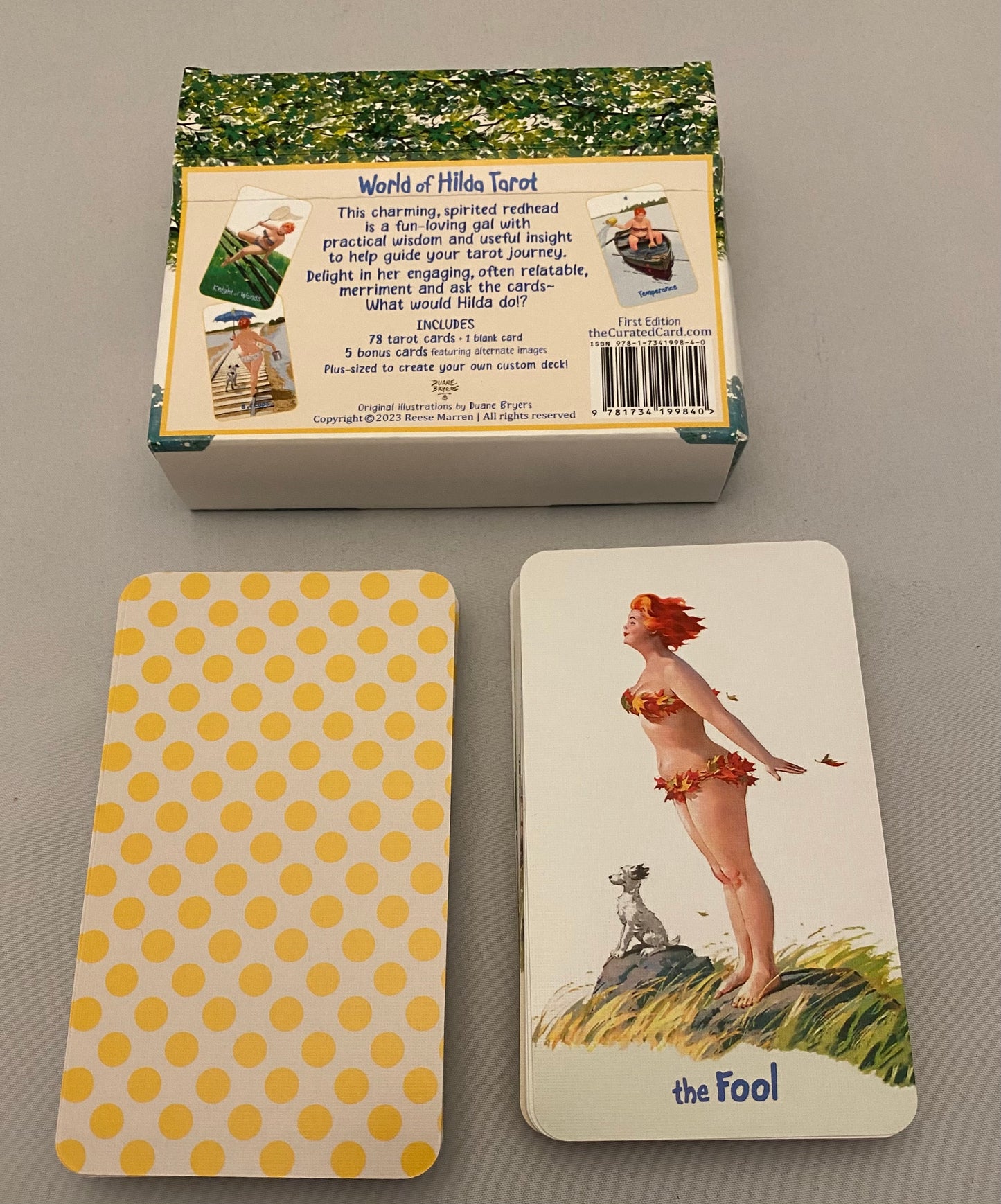 Two tarot cards and their packaging on a gray surface