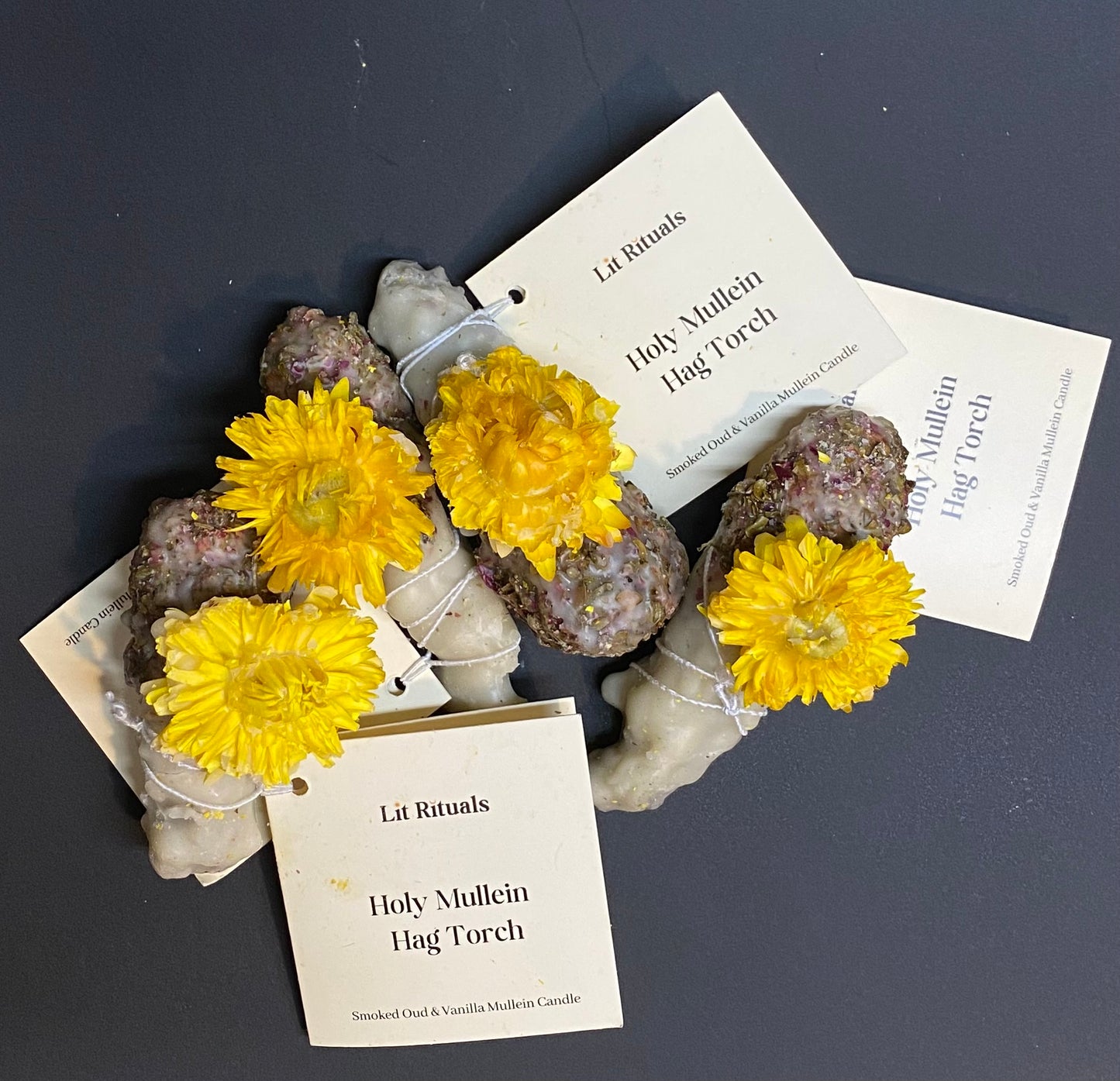 Mullein Candle with yellow flowers and rocks on a dark surface with 'Lit Rituals' labels.