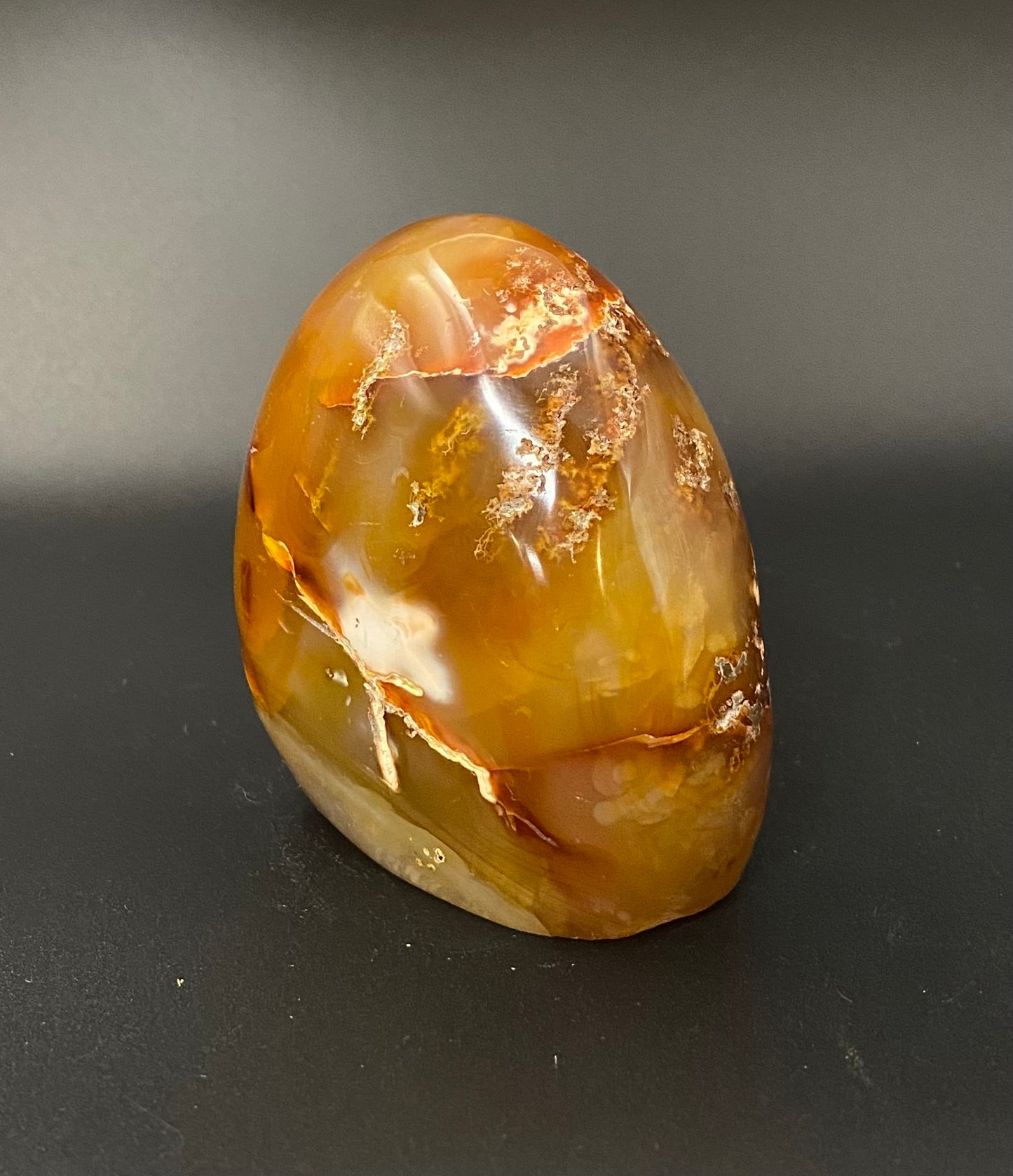 Polished carnelian stone on a dark background