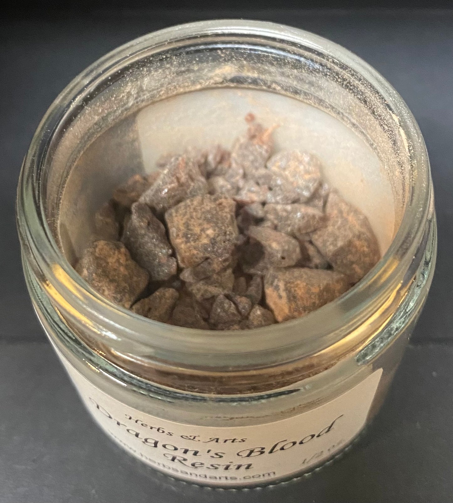 Jar of Dragon's Blood resin with a label on a dark background