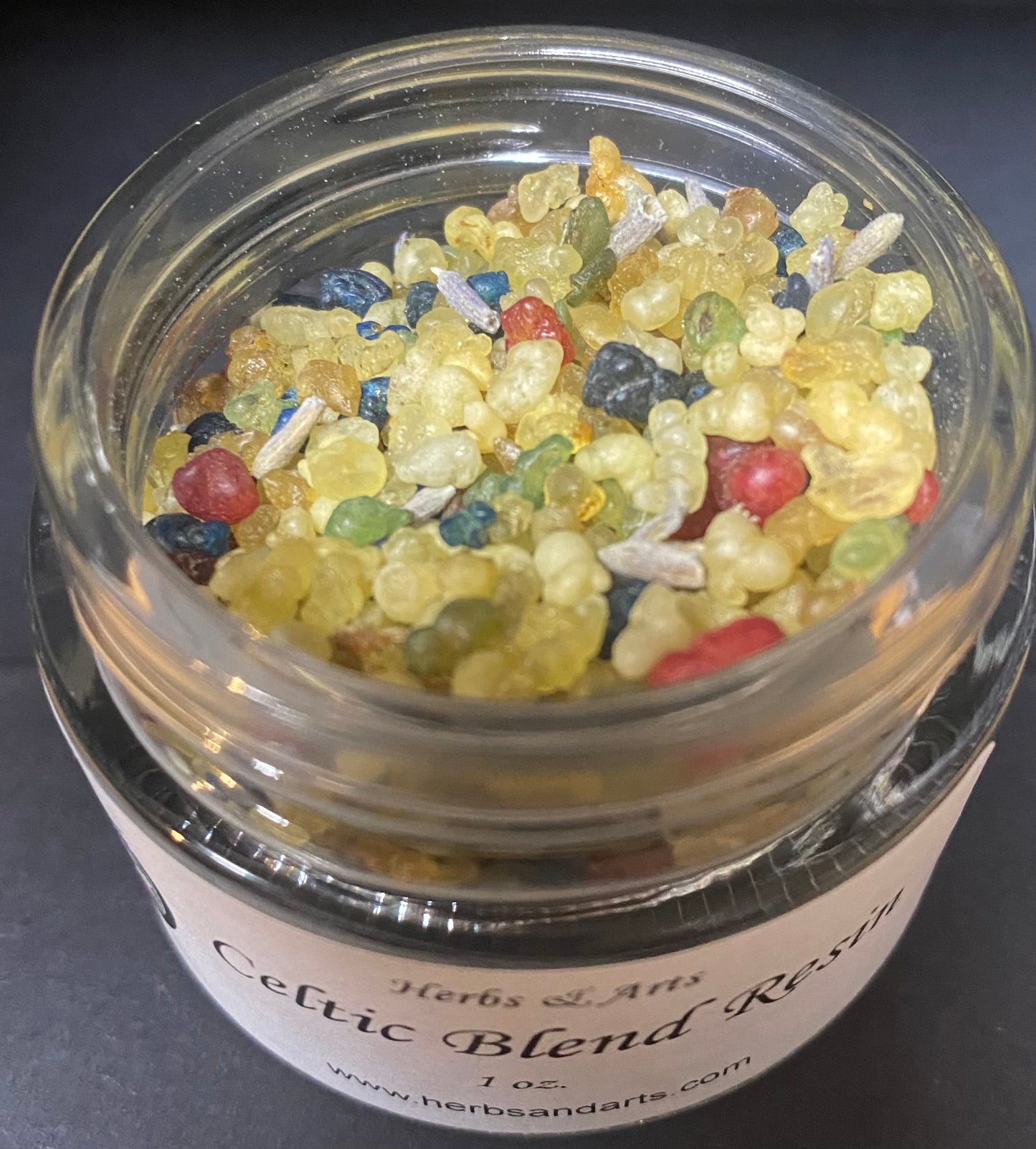 Jar of Celtic Blend Resin with colorful beads on a dark background