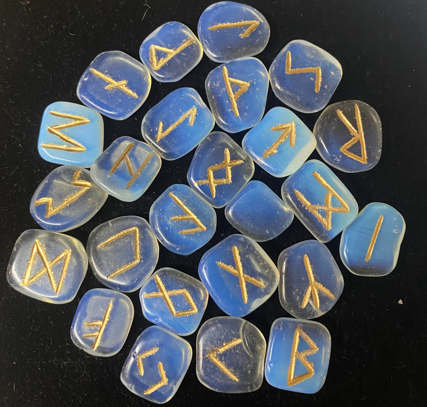 Rune Set Opalite stones with gold runes on a black background