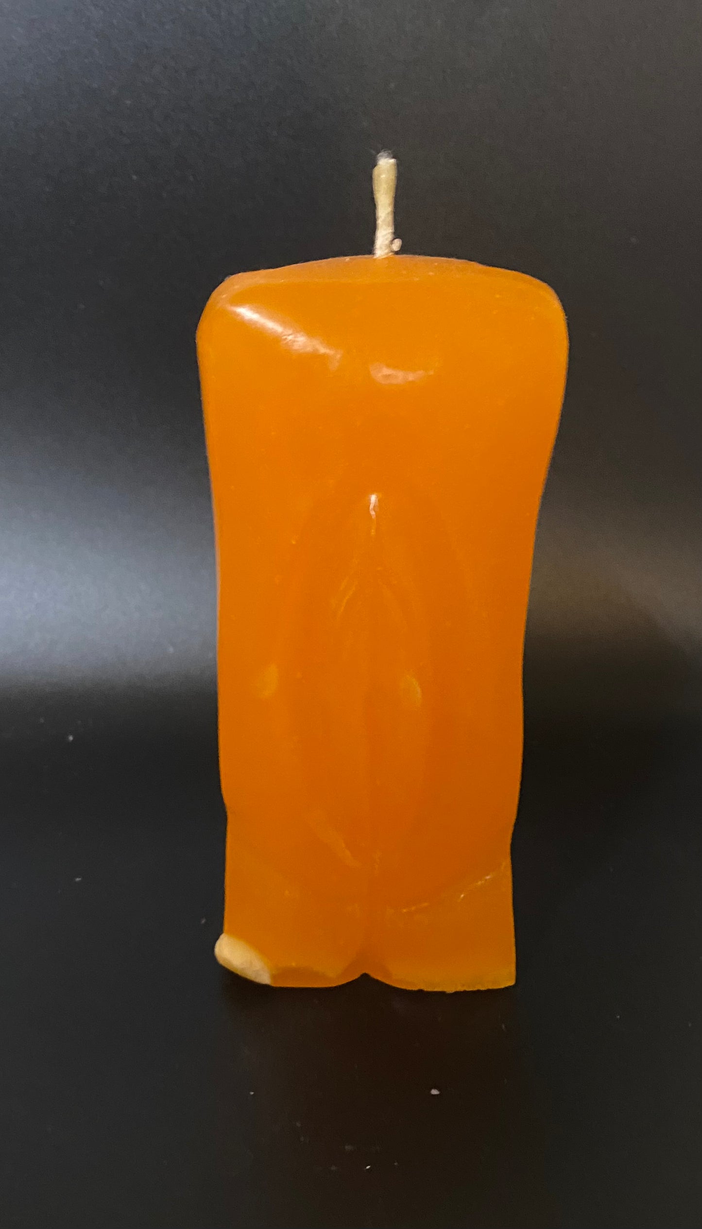 Rectangular orange candle on a black background
