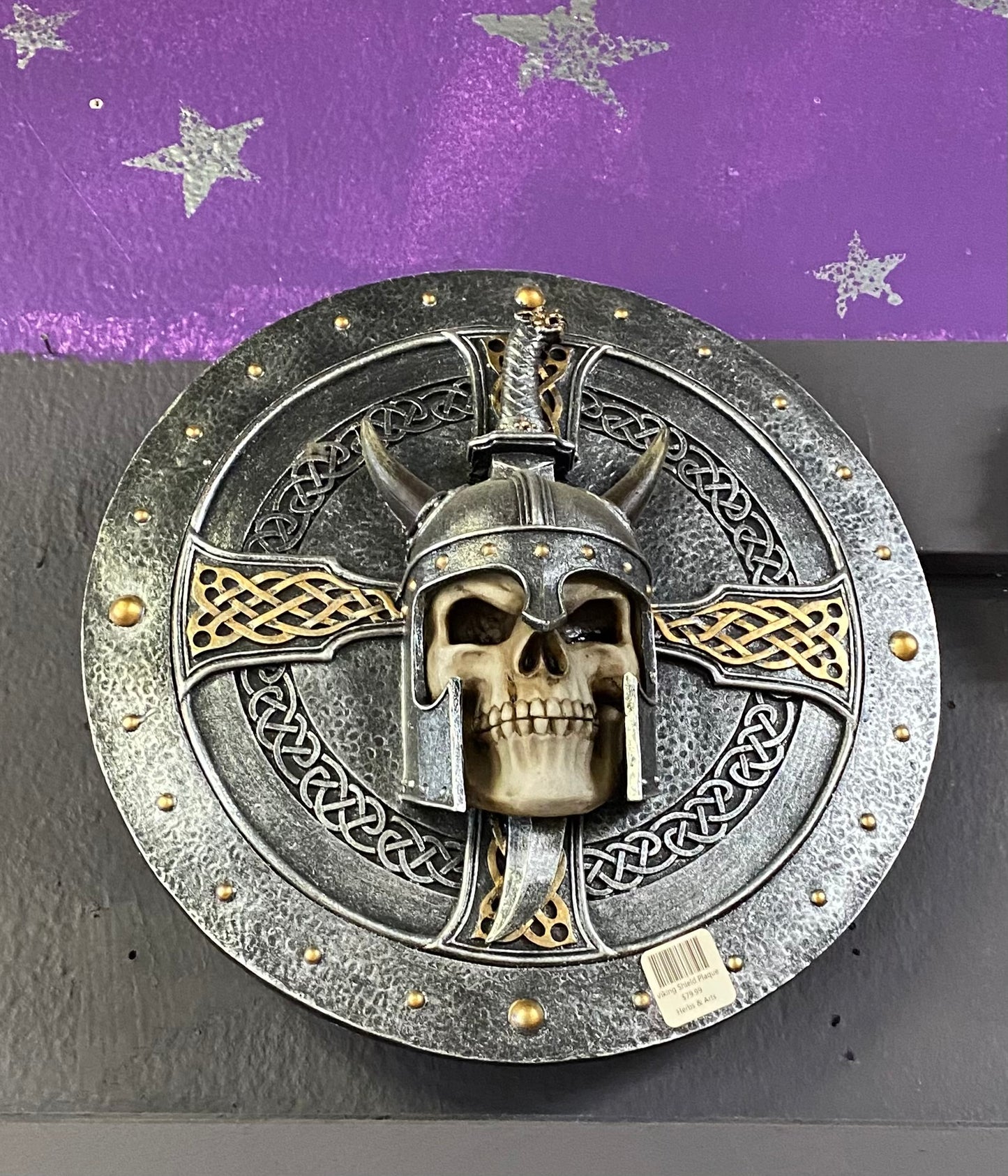 Decorative wall piece with skull and helmet design on a purple and gray background
