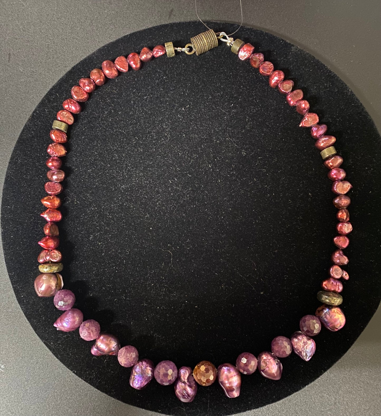 Necklace with pink and purple beads on a black background