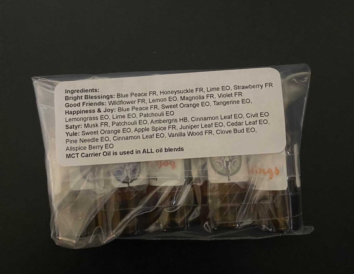 Packaged essential oil bottles with a label on a black background