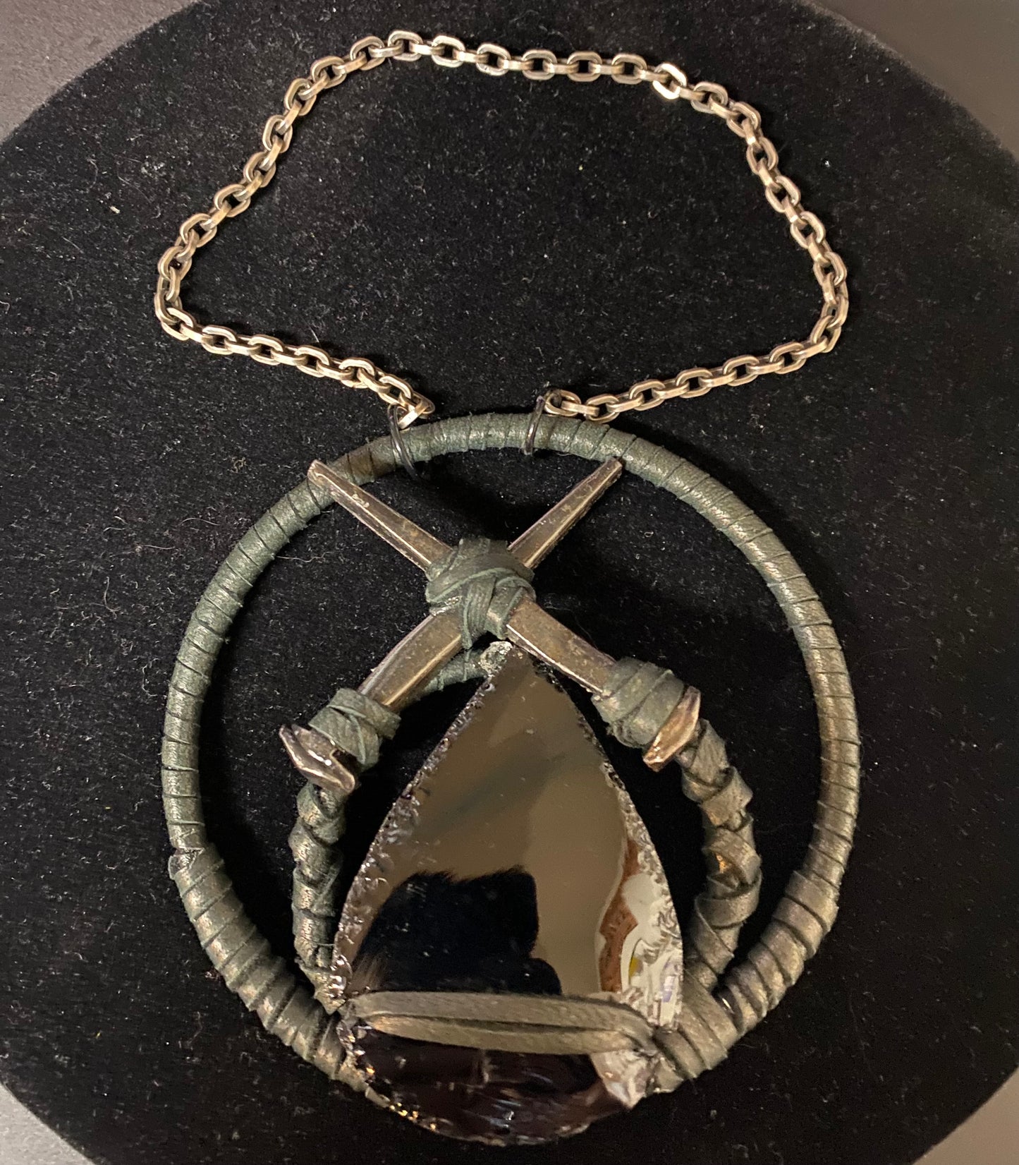 Necklace with a pendant featuring a cross and shield design on a black background