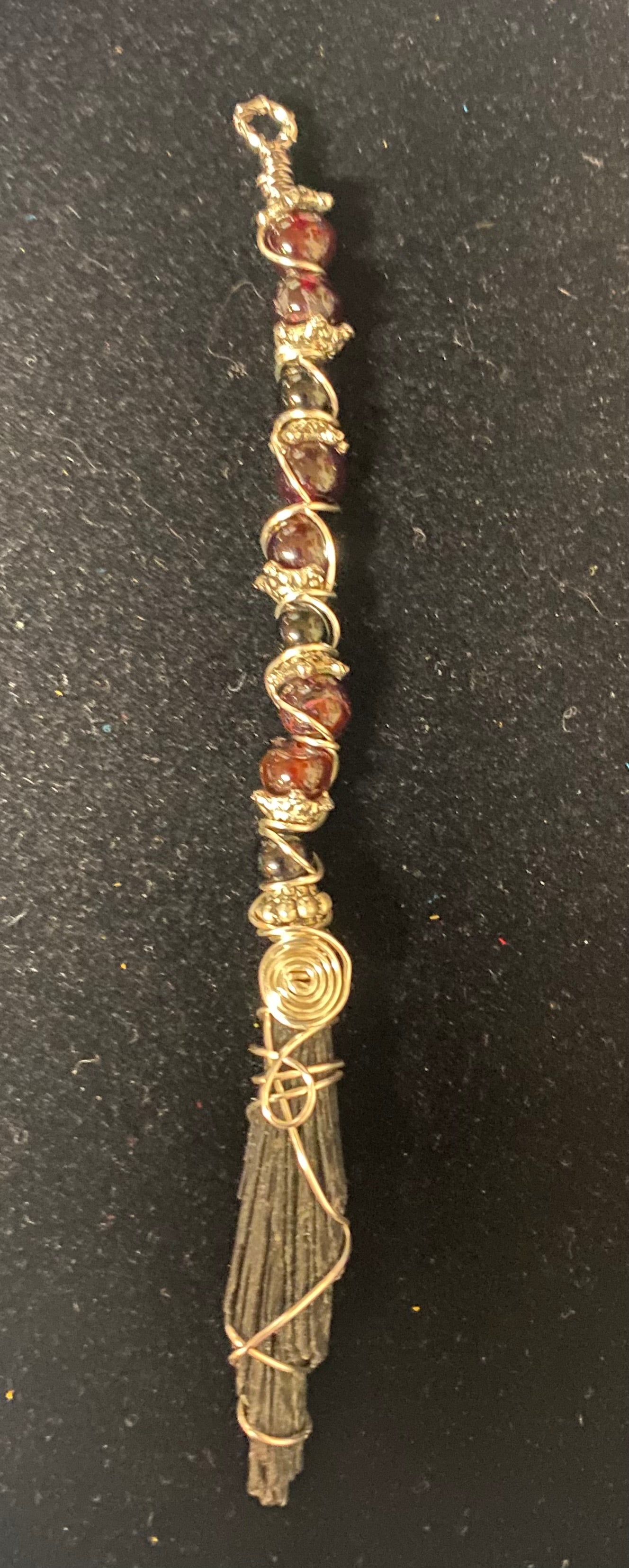 Decorative item with beads and wire on a black background