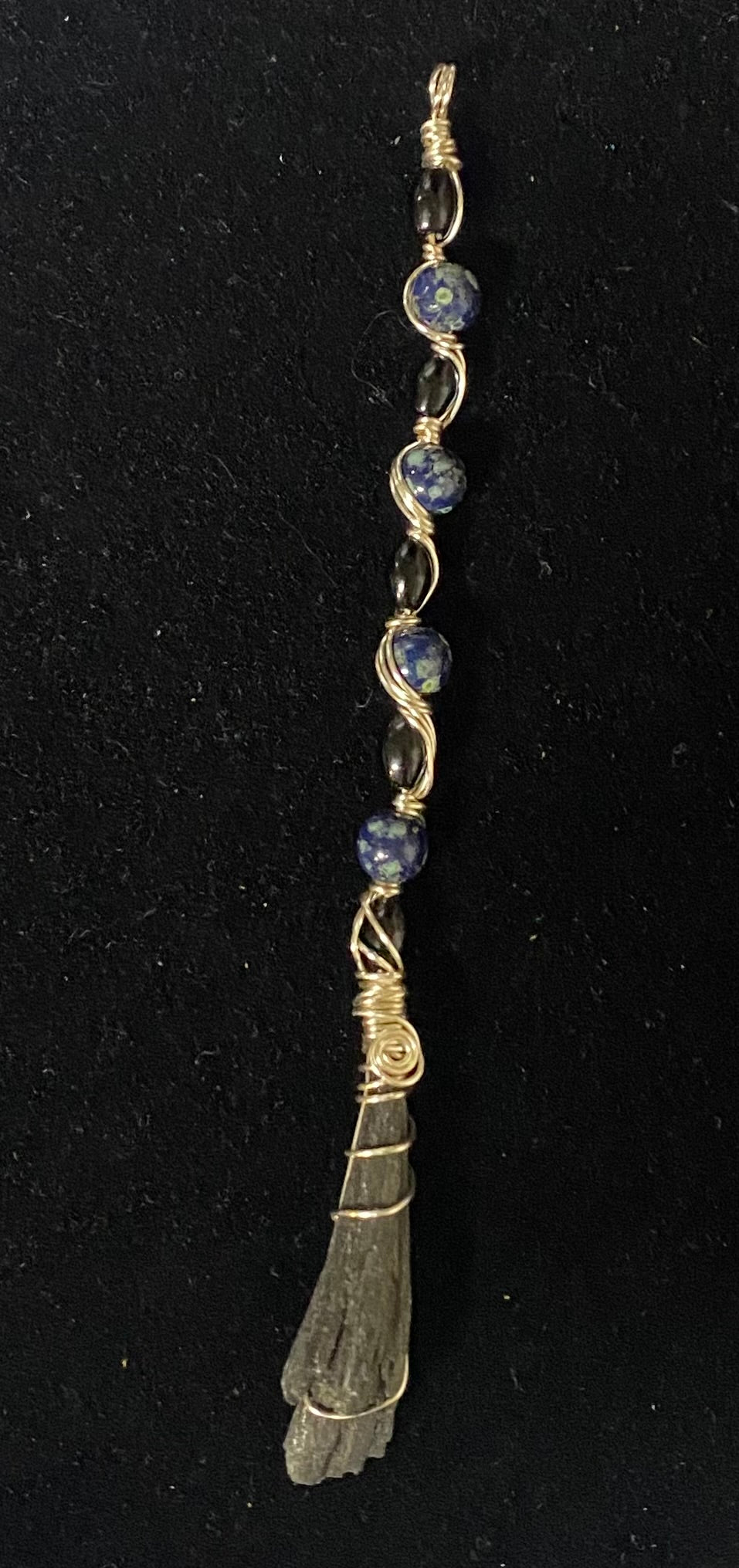 Jewelry with blue beads and a stone on a black background