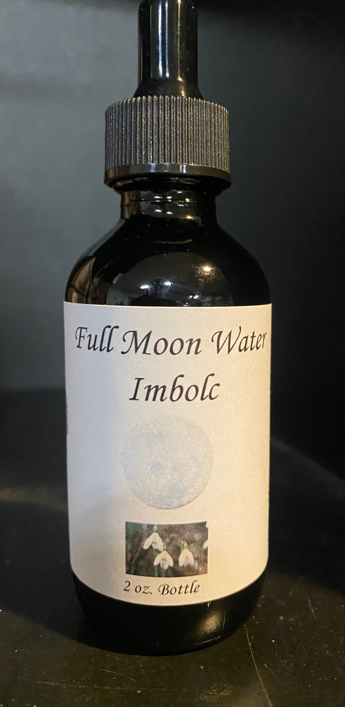 Bottle of 'Full Moon Water Imbolc' on a dark background