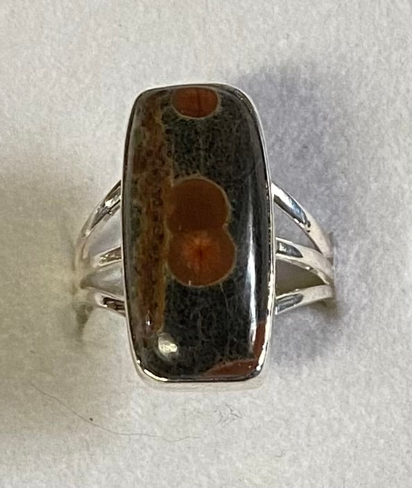 Silver ring with a rectangular stone on a light gray background