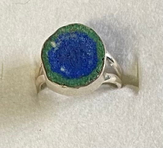 Silver ring with a blue stone on a white background