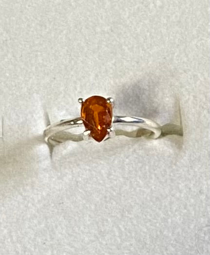 Silver ring with a brown gemstone on a light gray background