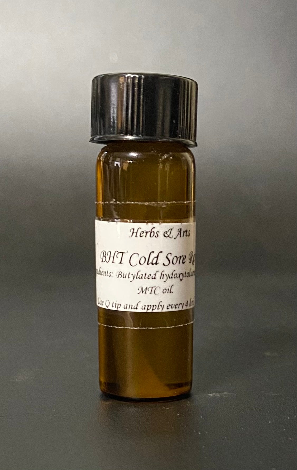 Small glass bottle with a label on a gray background