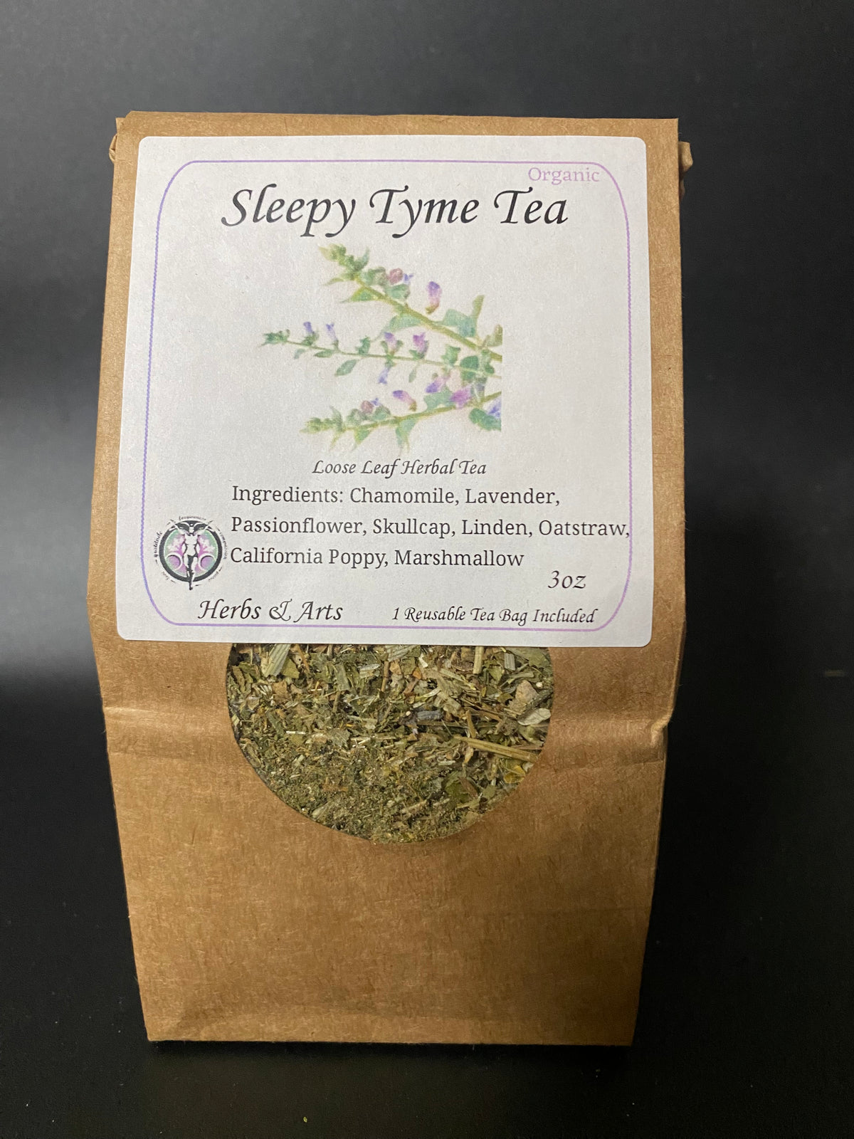 A stand-up kraft paper pouch of Sleepy Tyme Tea with a white label and a circular window showing loose leaf herbal tea inside, photographed against a dark background.