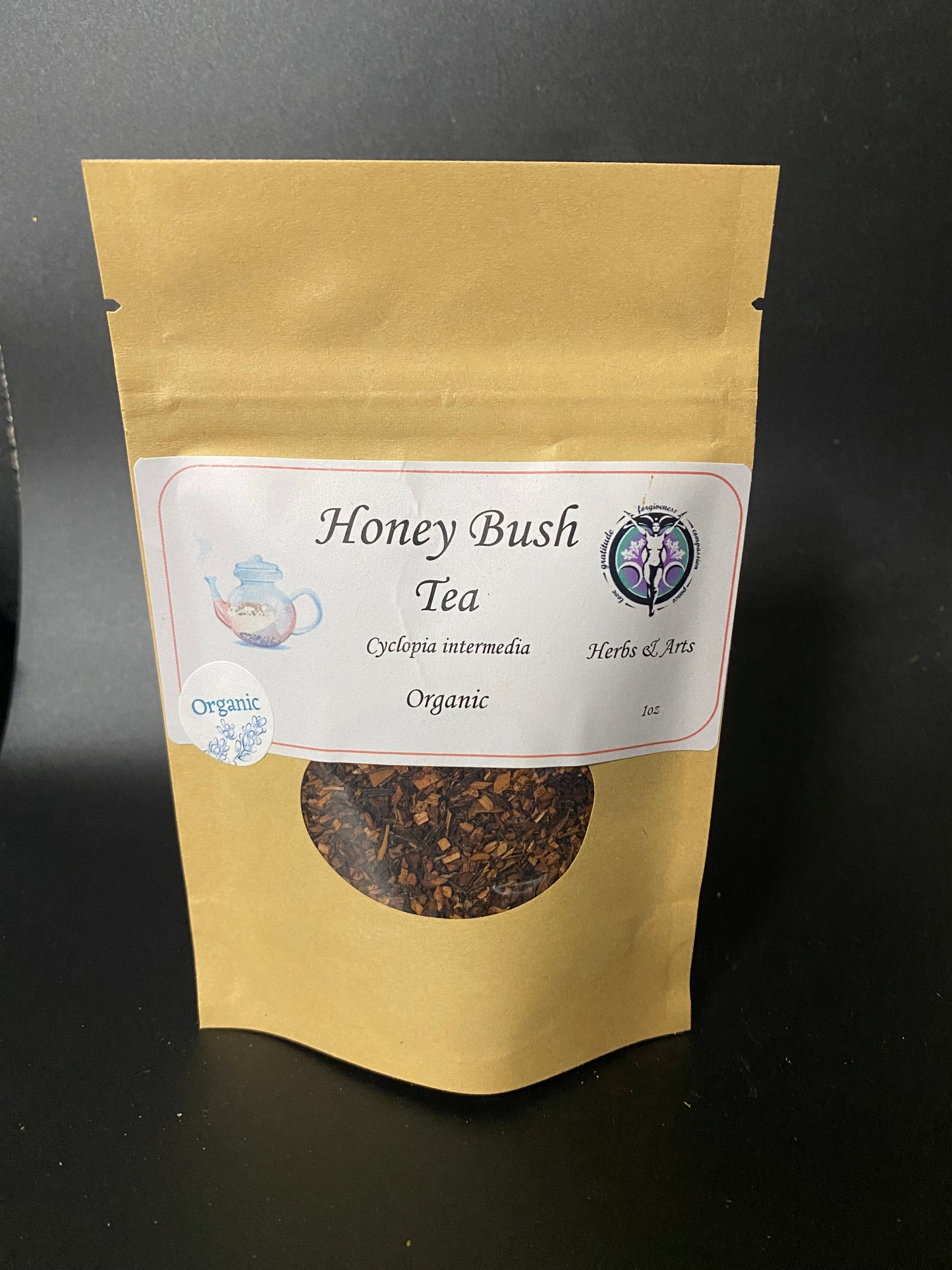A stand-up kraft paper pouch of Honey Bush Tea with a white label, set against a dark black background.