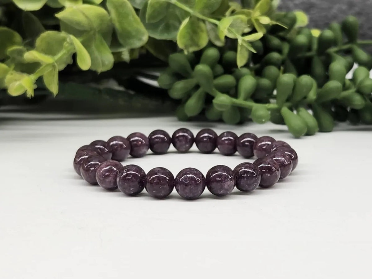 Bracelet Lepidolite 8mm on a white table with greener in background