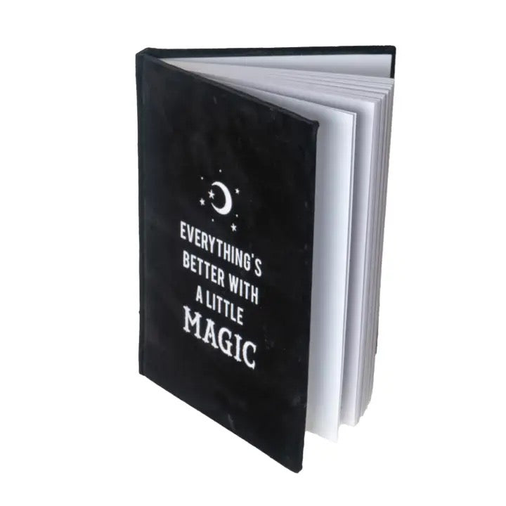 Black notebook with 'Everything's better with a little magic' text on a white background