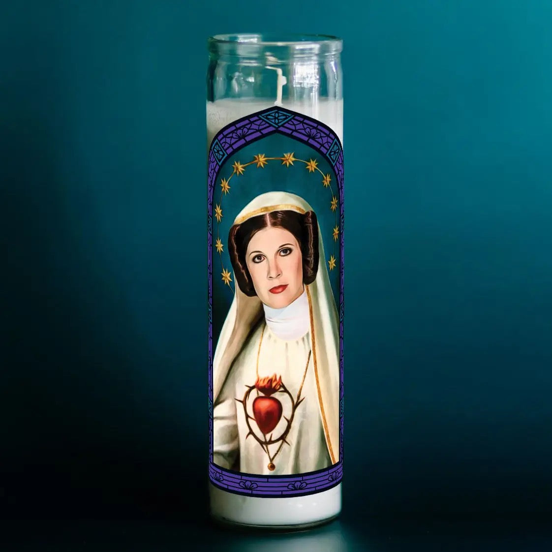 Candle with a religious icon design on a dark background