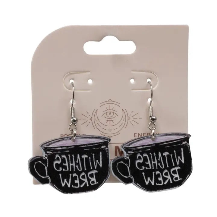 Black teacup earrings with 'Witches Brew' text on a beige card