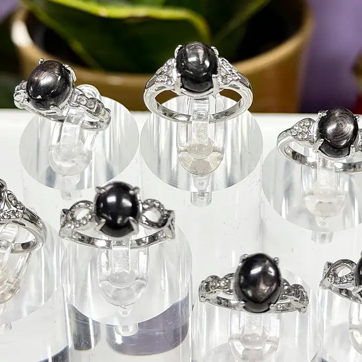 Set of silver rings with black gemstones on a white surface