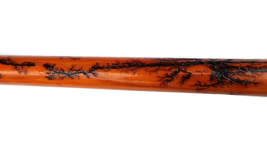 Wooden stick with black marbled pattern on a white background