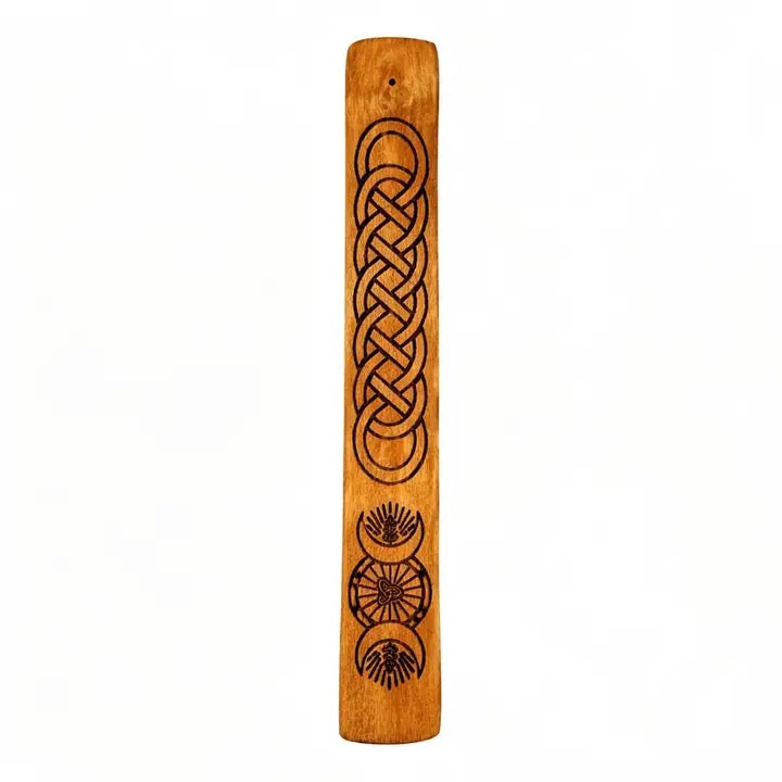 A vertical wooden incense holder featuring a dark brown engraved Celtic knot design and thistle motifs on a warm, natural wood background, isolated on a white background.