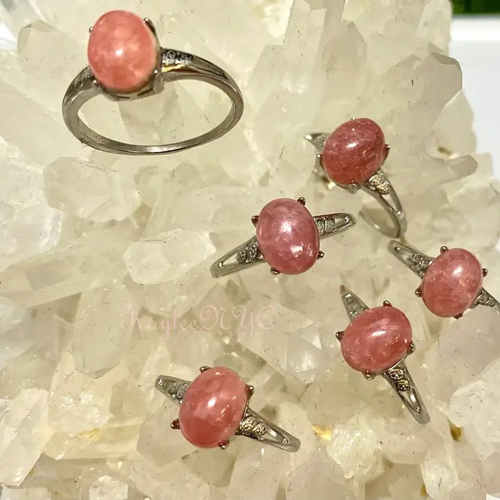 Silver rings with pink stones on a crystal background
