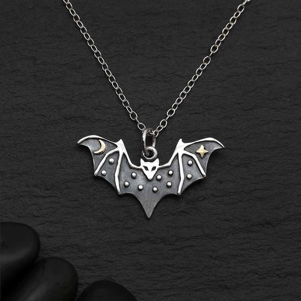 Silver bat pendant necklace on a dark background