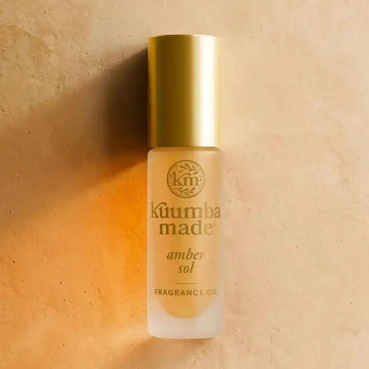 Kuumba Made amber sol fragrance oil bottle on a beige background