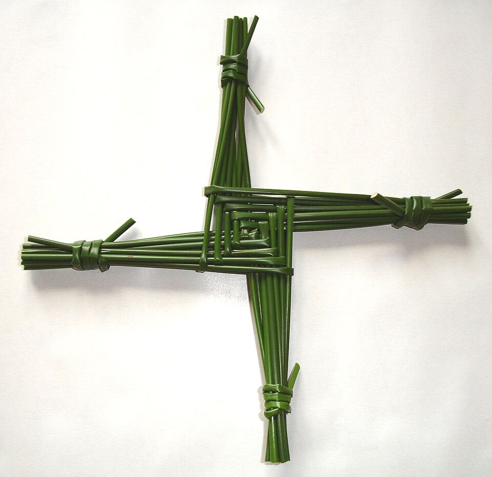 Green woven cross on a white background