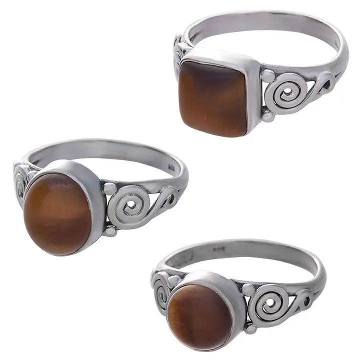 Three silver rings with brown gemstones on a white background