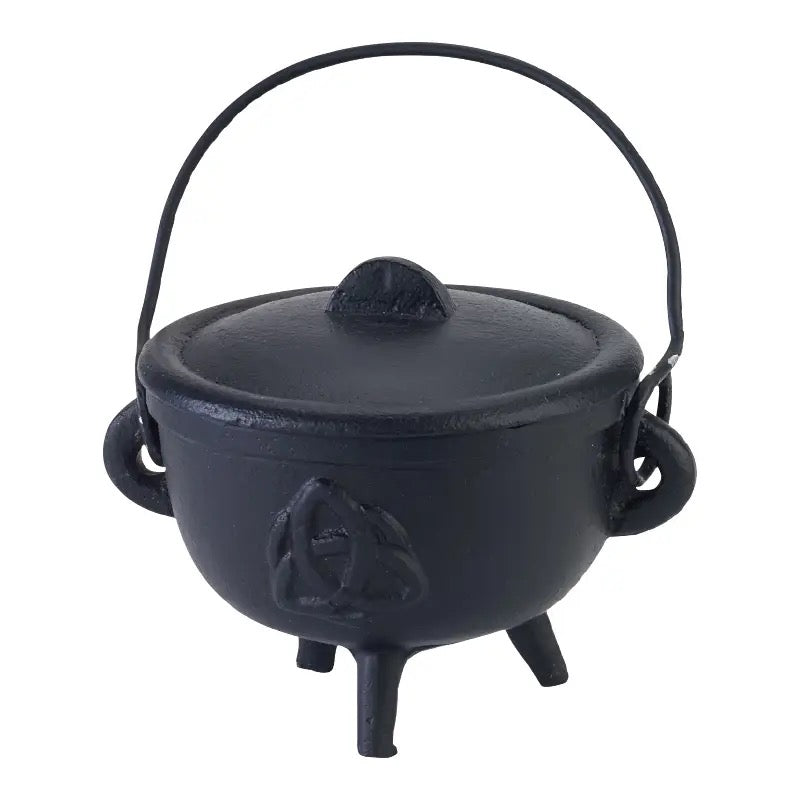 Black cast iron cauldron with lid on a white background