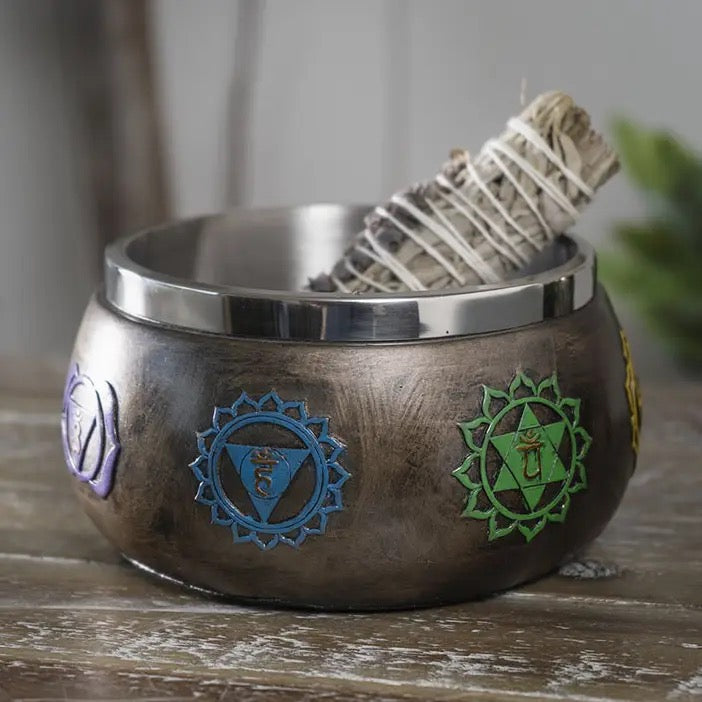 Wooden bowl with chakra symbols on a wooden surface