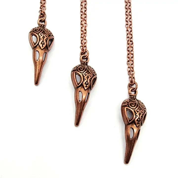 Copper bird beak pendant necklace on a white background