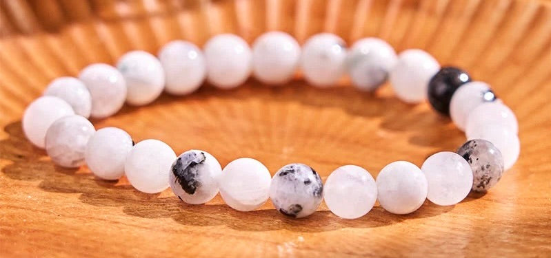 Bracelet with white and black beads on a wooden surface