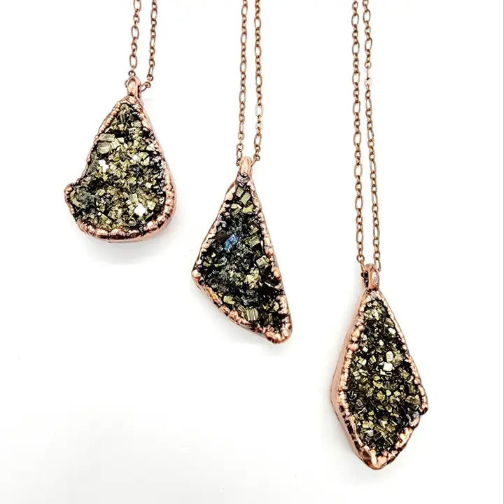 Three pyrite gold necklaces with teardrop-shaped, textured pendants on a white background.