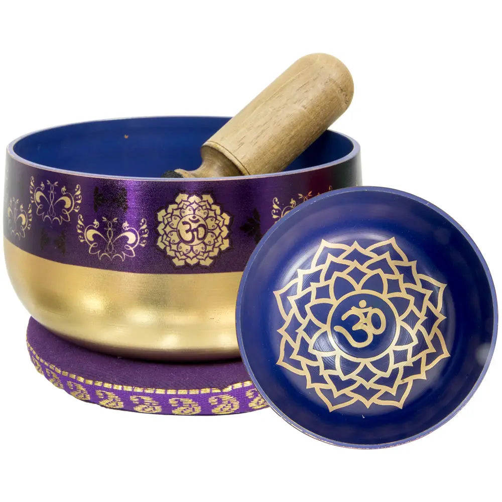 brass and burple singing bowl with depiction of crown charkra.