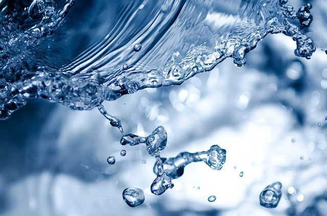 Close-up of water droplets and stream with a blurred background