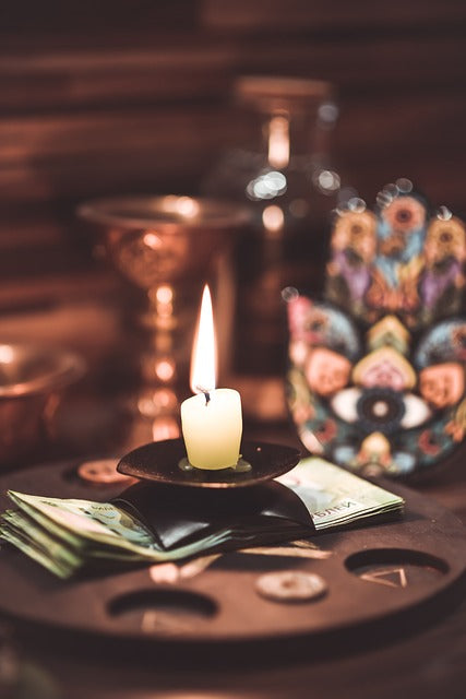 Candle and Hamsa image on a table