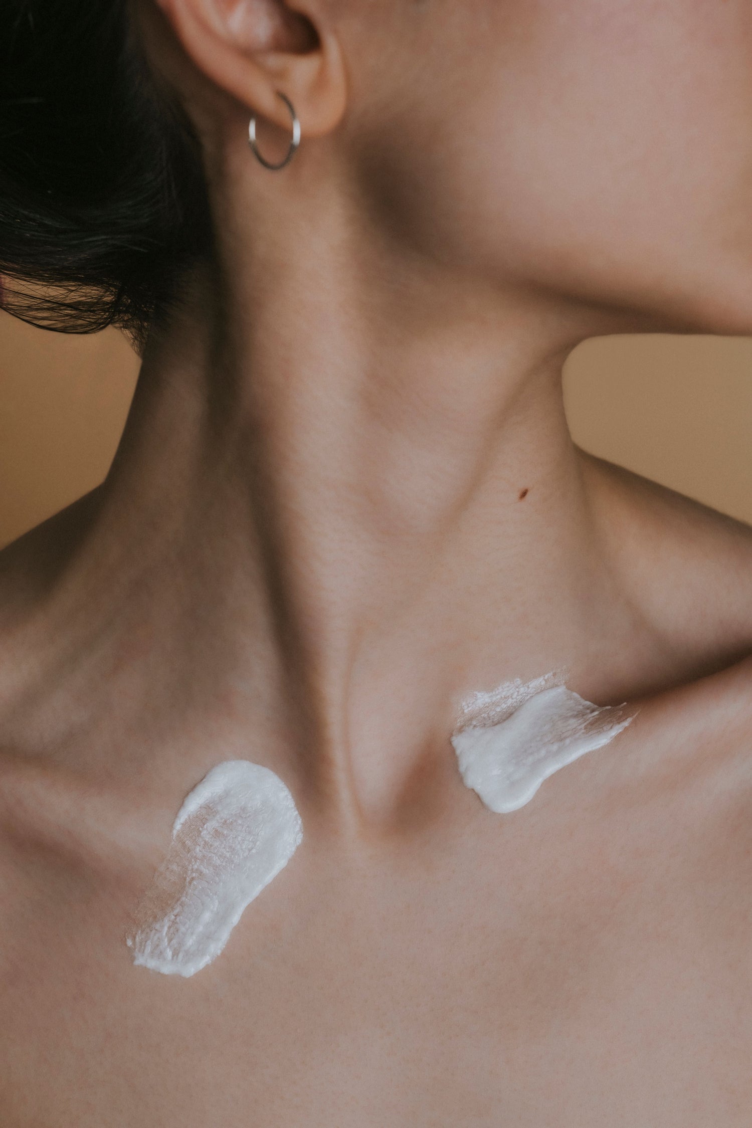 Body cream swatches on a neck of a woman