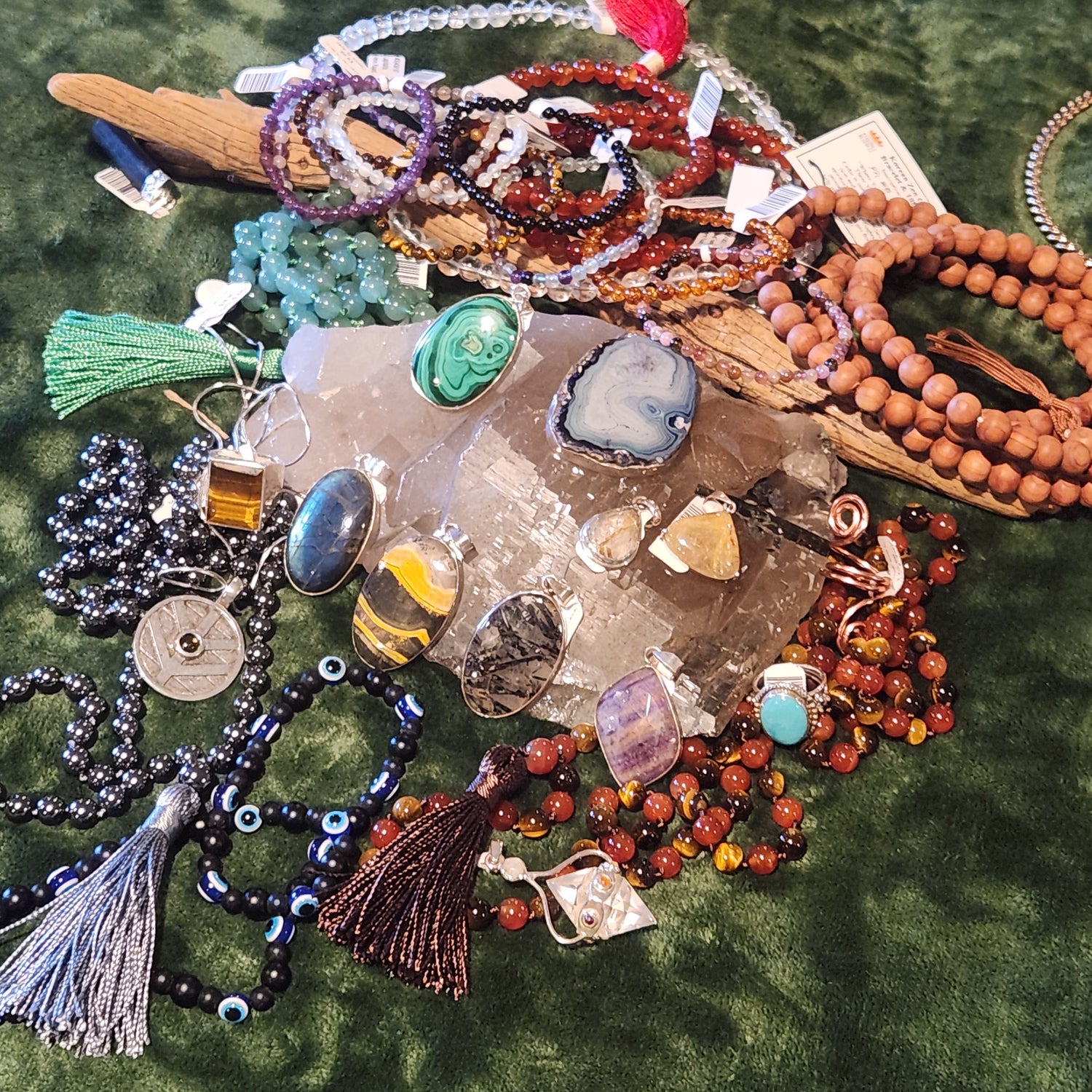 Assorted pendants and malas and bracelets on a crystal