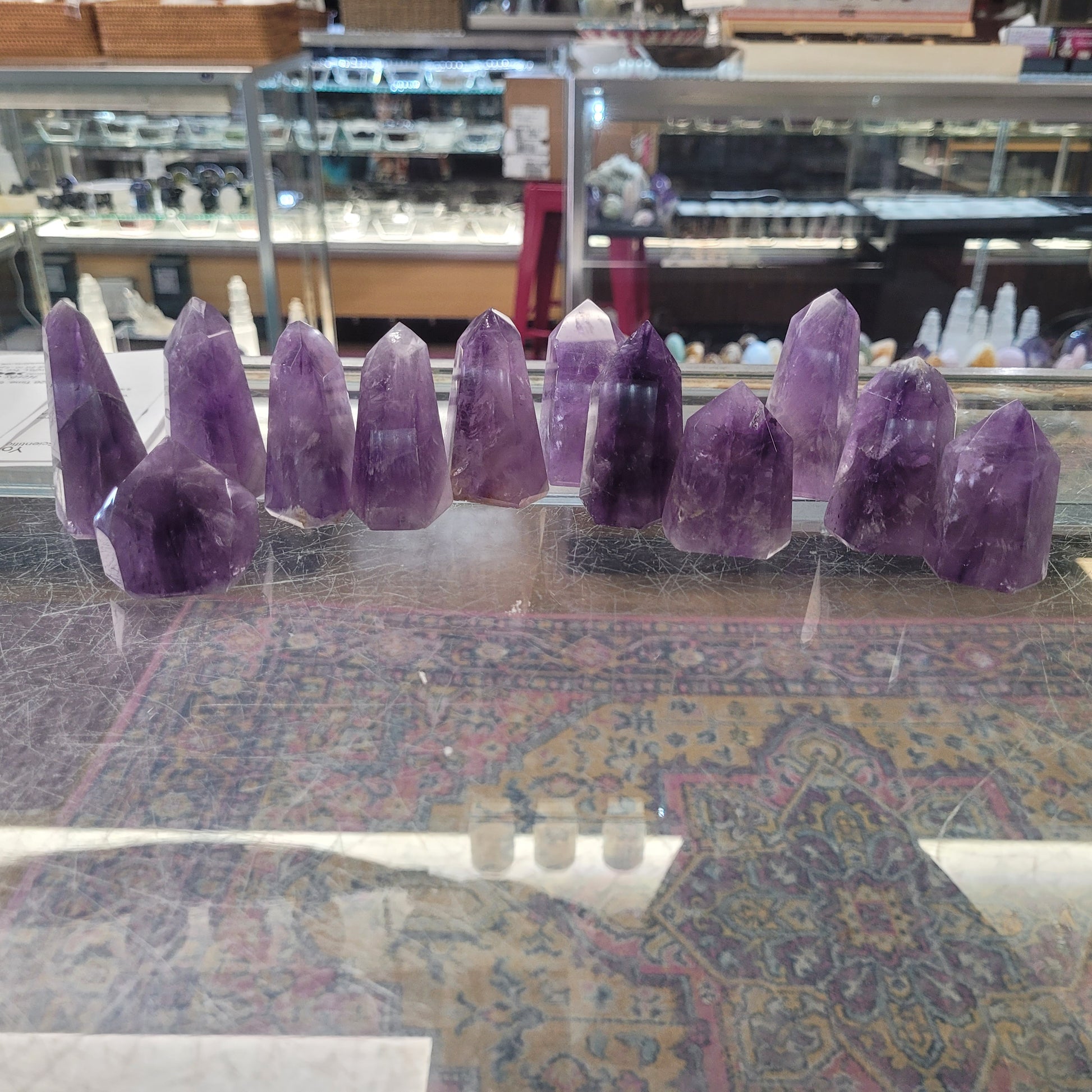 Purple crystal points hanging from a ceiling in a store setting