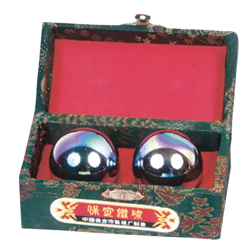 A pair of round, glossy, iridescent blue and purple decorative balls displayed inside an open green patterned presentation box with a red interior.