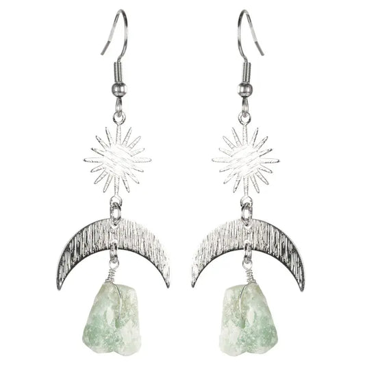Silver earrings with star and moon designs and green stones on a white background