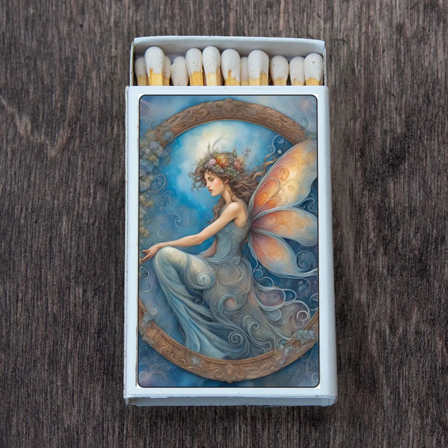 fairy perched inside a wreath like image, blues and oranges.